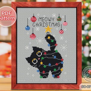 May include: A cross-stitch pattern featuring a black cat dressed as a Christmas tree. The cat is decorated with colourful ornaments and lights. The text "MEOWY CHRISTMAS" is written above the cat.