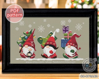 Puede incluir: Tres gnomos en una escena de invierno nevada. El gnomo de la izquierda lleva un pequeño árbol de Navidad. El gnomo del medio lleva un gorro rojo y sostiene una bola roja. El gnomo de la derecha lleva una pila de regalos envueltos. El texto "SO-OP2182" está en la esquina inferior derecha de la imagen.