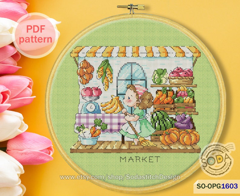 May include: A cross-stitch pattern of a girl in a green dress standing in front of a market stall with a variety of fruits and vegetables. The stall has a sign that says "MARKET".