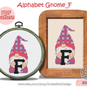 May include: Cross stitch pattern for a gnome holding the letter F. The gnome is wearing a purple and red plaid hat and has a red beard. The letter F is black. The pattern is in a wooden frame.