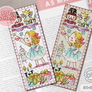 May include: Cross stitch bookmark pattern featuring a girl in a blue dress holding a red bauble, a nutcracker, and a mouse. The pattern is on a white background with red, green, and gold accents. The pattern is labelled "SO-BM45".