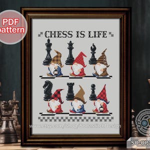 Può includere: Schema di punto croce con una scacchiera con gnomi vestiti come pezzi degli scacchi. Il testo "Chess is Life" è sopra la scacchiera. Lo schema è in una cornice marrone.