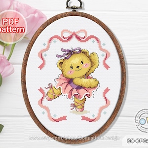 May include: A cross stitch pattern featuring a cute teddy bear dressed as a ballerina. The bear is wearing a pink tutu and pink shoes. The pattern is surrounded by pink ribbons and stars.