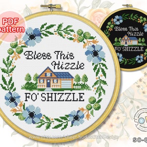 May include: A cross-stitch design in a wooden hoop, displaying the text "Bless This Hizzle Fo' Shizzle" and a house illustration. The design incorporates blue flowers and green leaves. A smaller version is also shown.