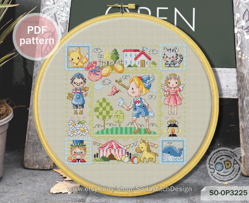 May include: A colorful cross-stitch pattern featuring a whimsical scene with a girl, a boy, a cat, a fox, a house, a tent, a carousel horse, and a whale. The pattern is framed in a wooden hoop and includes the text "SO-OP3225".