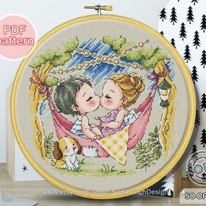 May include: Cross stitch pattern of two children kissing in a hammock under a starry sky. The children are wearing striped shirts and have blonde and brown hair. A small dog is sitting in the grass below them. The pattern is in a round hoop and includes the text "SO-OP3238" and "www.etsy.com/shop/SodastitchDesign".