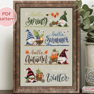 Puede incluir: Cuatro gnomos, cada uno representando una estación diferente, se representan en un patrón de punto de cruz. Los gnomos sostienen carretillas llenas de artículos de temporada, como flores, una pelota de playa, calabazas y una casa de jengibre. El texto "hello spring", "hello summer", "hello autumn" y "hello winter" está escrito encima de cada gnomo.