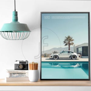 May include: A framed poster with a white Porsche 930 driving by a pool in a desert landscape. The poster is titled "930" and has a blue sky and white clouds in the background.