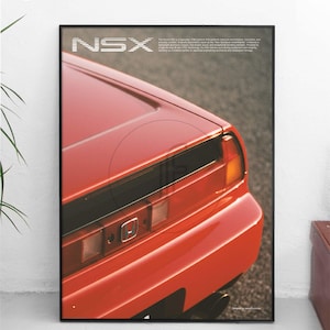 Puede incluir: Un póster enmarcado con un primer plano de la parte trasera de un coche deportivo rojo. El póster tiene la palabra "NSX" en letras blancas en la parte superior. Se ven los faros traseros y el tubo de escape del coche.