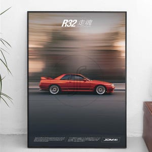 May include: A framed poster featuring a side profile of a red R32 sports car in motion against a blurred background. The text R32 走魂 is printed at the top, with additional descriptive text and the JDM logo located at the bottom of the print.