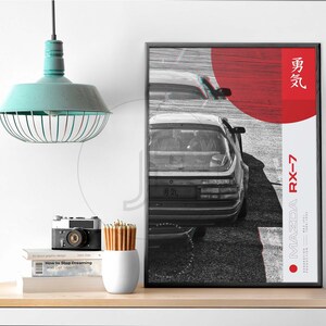Puede incluir: Un p&oacute;ster en blanco y negro con un c&iacute;rculo rojo y texto japon&eacute;s. El p&oacute;ster presenta una foto en blanco y negro de un Mazda RX-7. El texto en el p&oacute;ster dice "Mazda RX-7" y "勇気".