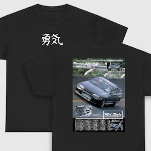 May include: Black t-shirt with a white Japanese character on the front and a black and white image of a car on the back. The image includes the text "ノーマル風味の快速GT-R" and "最高速 283.05km h" and "Mid Night".