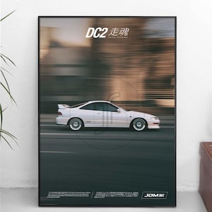 Könnte beinhalten: Ein gerahmtes vertikales Poster mit einem weißen Coupé in Bewegung vor einem verschwommenen Hintergrund. Der Text DC2 走魂 ist oben aufgedruckt, mit zusätzlichem beschreibendem Text und einem JDM-Logo unten. Das Auto ist im Profil zu sehen.