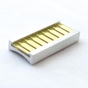 Op de afbeelding: Een zilverkleurige USB-connector met goudkleurige pinnen. De rechthoekige connector heeft een licht gebogen ontwerp aan de zijkanten. De pinnen zijn zichtbaar aan de bovenkant van de connector.
