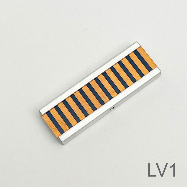 Peut inclure: Une garniture d&eacute;corative ray&eacute;e argent et noire avec une finition en bois. La garniture mesure environ 25 cm de long.