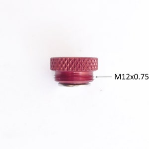 May include: A maroon-colored metal component with a textured top and threaded base. The text "M12x0.75" is printed on the side, indicating the size and thread pitch of the component. The object is set against a white background.