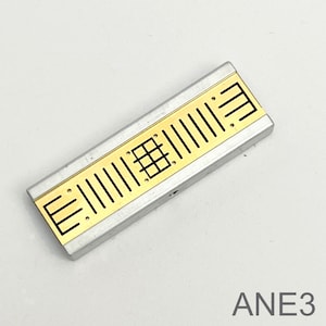 Peut inclure: Un composant &eacute;lectronique rectangulaire argent&eacute; et dor&eacute; avec un motif en grille et le texte "ANE3" imprim&eacute; sur la surface blanche en dessous.