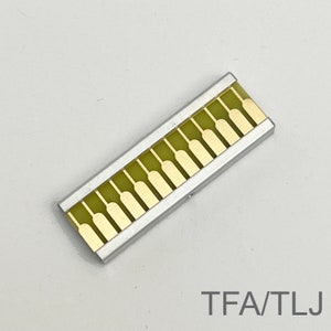 Peut inclure: Un composant &eacute;lectronique argent&eacute; et dor&eacute; avec 14 contacts dor&eacute;s. Le composant est &eacute;tiquet&eacute; "TFA/TLJ".