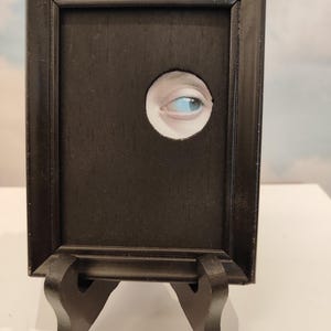 Curiosity – eye extracted from a painting, repurposed art, framed collage, mixed media, circular opening, unique piece