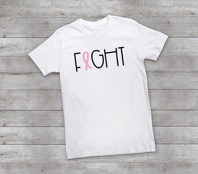 May include: White t-shirt with the word "FIGHT" in black text and a pink ribbon graphic.