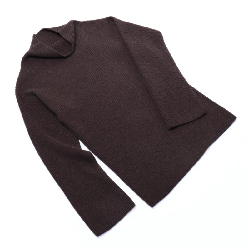 May include: A brown ribbed knit sweater with a cowl neck.