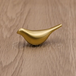 May include: A gold-colored bird-shaped cabinet knob or drawer pull.