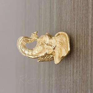 May include: A gold-colored elephant-shaped cabinet knob.