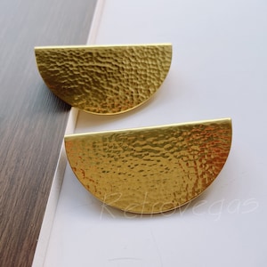 May include: Two gold-toned metal half-circle earrings with a hammered texture.