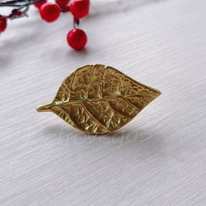 May include: A gold leaf-shaped decorative door knob with a detailed textured design.