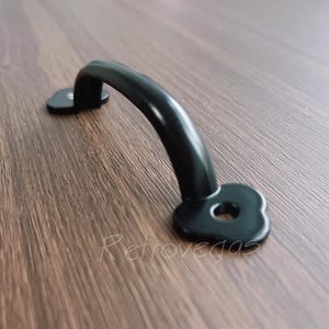 Op de afbeelding: Zwarte metalen kastdeurknop met een hartvormig ontwerp.