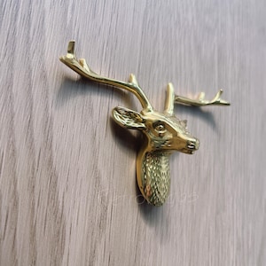 May include: Gold-toned deer head wall hook with antlers.