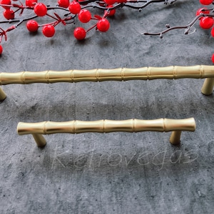 May include: Two gold-toned bamboo-style cabinet pulls. The larger pull is 25.4 cm long and the smaller pull is 15.2 cm long.