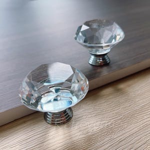 Può includere: Due pomelli per armadi in vetro trasparente a forma di diamante con basi in metallo argentato.