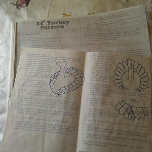 May include: Open sewing pattern for a 14-inch turkey, with instructions and diagrams. The pattern is on aged paper, with a hand-drawn turkey illustration. The background is a floral patterned fabric.
