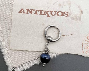 May include: A silver hoop earring with a dangling blue gemstone bead. The earring is on a white background with the word "ANTIKUOS" printed in brown.