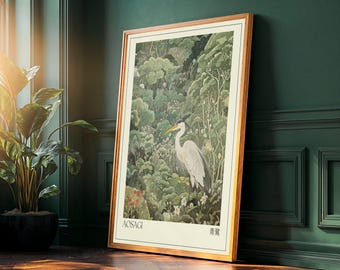 May include: Framed art print featuring a Japanese-style illustration of a heron in a lush forest. The artwork is predominantly green with white and red accents, set against a cream background. The frame is a warm, light brown color. The text "AOSAGI" and Japanese characters are visible.