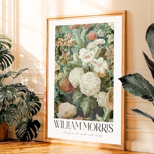 May include: A framed floral print with a detailed botanical design. The print features white, cream, and red flowers against a teal background. The print is labeled "WILLIAM MORRIS" with the text "Transform the world with beauty."