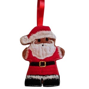Könnte beinhalten: Weihnachtsbaumschmuck in Form eines Weihnachtsmanns. Der rote Filz-Ornament hat weiße Verzierungen, einen schwarzen Gürtel und ein braunes Gesicht. Es hat einen weißen Bart und ein rotes Band zum Aufhängen.