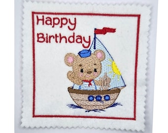 Tarjeta de cumpleaños con un oso bordado en forma de barco