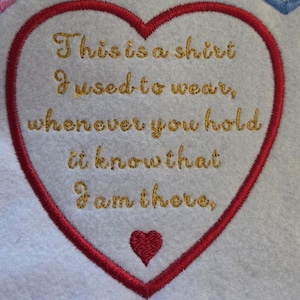 May include: A white fabric patch shaped like a heart with a red embroidered border. The centre features gold embroidered text that reads: This is a shirt I used to wear, whenever you hold it know that I am there, with a small red heart below.