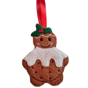May include: A felt gingerbread man Christmas ornament with a red ribbon. The brown gingerbread man has white icing, a green holly accent, and a smiling face. A festive decoration for the holiday season.