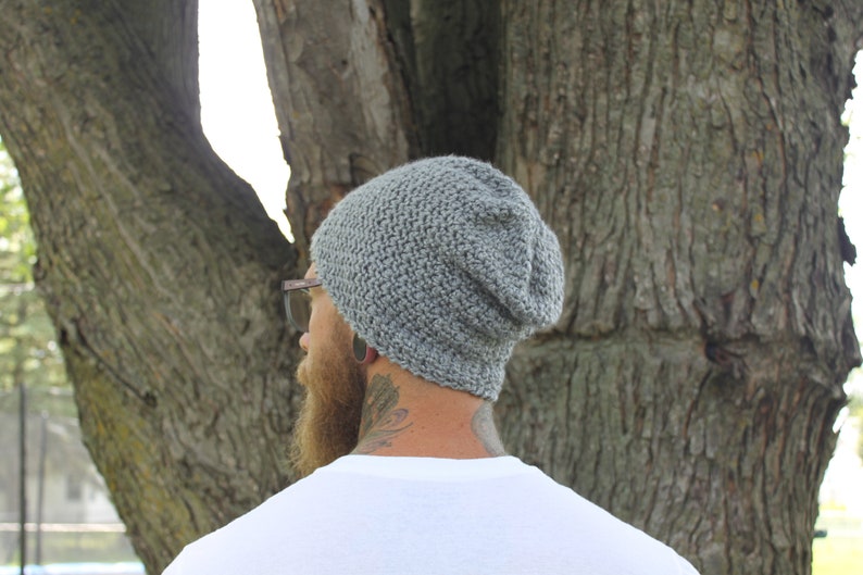 May include: A gray slouchy beanie hat with a textured knit pattern.