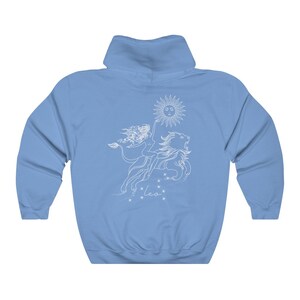 May include: A light blue hoodie with a white graphic of a woman riding a lion with a sun above them. The graphic also includes the word "Leo" below the lion.