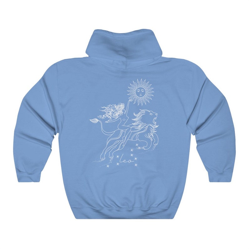 May include: A light blue hoodie with a white graphic of a woman riding a lion with a sun above them. The graphic also includes the word "Leo" below the lion.