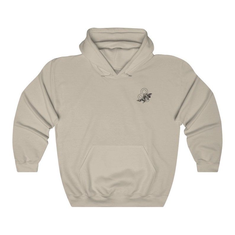 May include: A light beige hoodie with a black floral design featuring the astrological symbol for Leo.