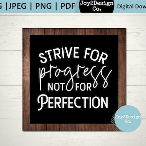 Puede incluir: Una pizarra negra con marco de madera muestra el texto "STRIVE FOR progress NOT FOR PERFECTION" en letras blancas. El texto está escrito a mano. La esquina inferior derecha de la imagen muestra un logotipo con el texto "Joy2Design Co."