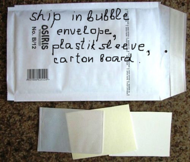 May include: A white bubble envelope with handwritten text and a barcode. Below the envelope are several small, clear and white rectangular pieces of paper.