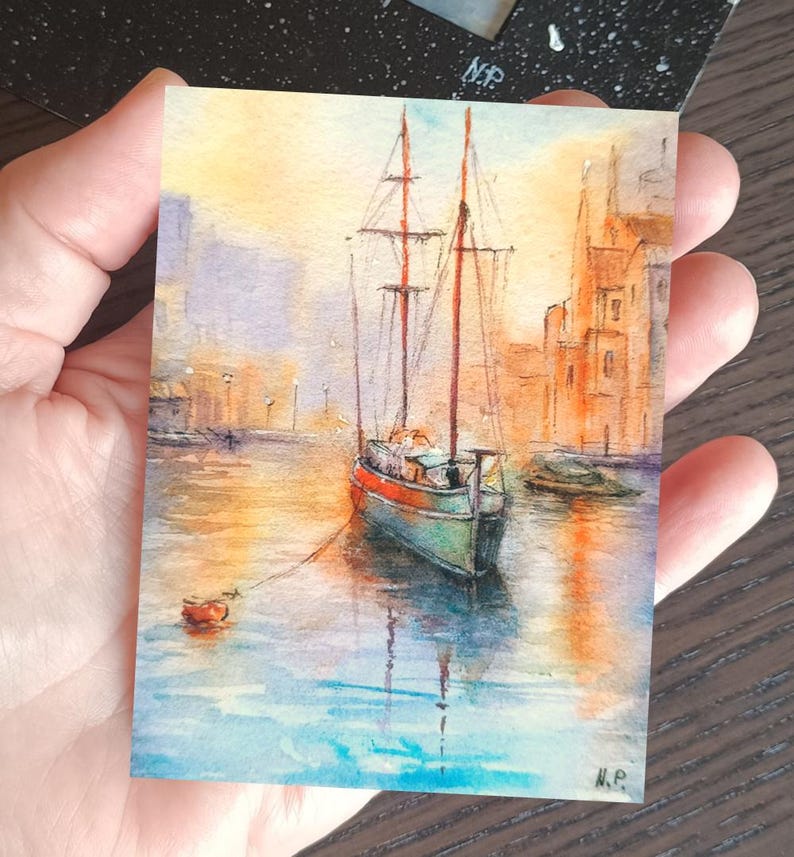 This ACEO painting (6 × 9 cm) captures a peaceful boat ride through a glowing marine, surrounded by warm architecture and reflections on water. The soft light and expressive brushwork create a romantic art.