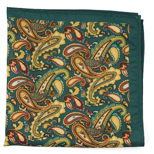Può includere: Un fazzoletto da taschino quadrato, verde smeraldo, con un motivo paisley dettagliato. Il design paisley presenta accenti gialli, arancioni e bianchi su uno sfondo verde scuro. Il fazzoletto ha un bordo verde scuro.