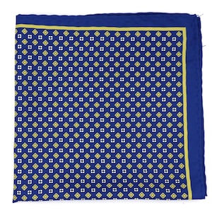 Può includere: Un fazzoletto da taschino blu navy con un motivo ripetuto di forme floreali gialle e bianche. Il bordo è una linea gialla piena e i bordi sono blu navy scuro.